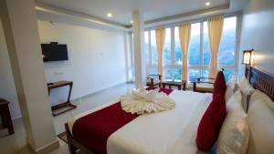 um quarto com uma grande cama branca com almofadas vermelhas em Carmel Top Munnar em Munnar