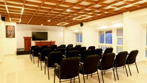 a conference room with chairs and a podium and a screen at Carmel Top Munnar in Munnar