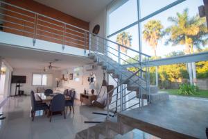a living room with a staircase and a dining room at Pacific Shores Retreat & Getaway in Nuevo Vallarta 