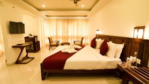 una camera d'albergo con un grande letto e una scrivania di Carmel Top Munnar a Munnar