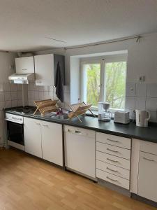 a kitchen with white cabinets and a black counter top at Wohnung Apartments Beny in Bad Bellingen