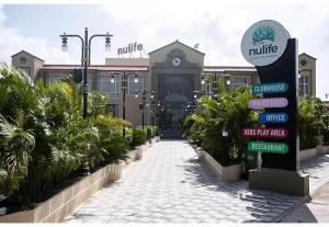 um edifício com um sinal em frente em Nulife Resort em Jamnagar