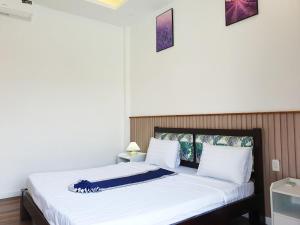 1 dormitorio con 1 cama grande con sábanas blancas en Chavi Beach - Coffee and Homestay en Bình Tú