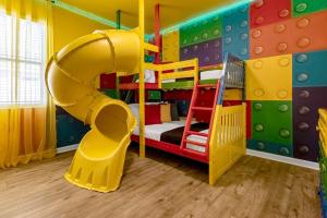 a play room with a slide and a bunk bed at Family Resort - 12BR Mansion - Sleeps 28 - Private Pool, BBQ and Games Room! in Kissimmee