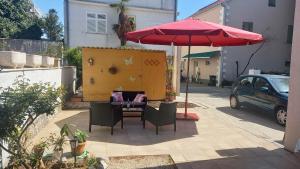 a table with chairs and an umbrella on a patio at Apartman Mir in Kaštela