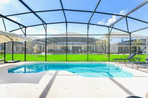 una piscina en un edificio con techo de cristal en 10BR Luxury Home Near Disney w Pool & Games Room, en Kissimmee