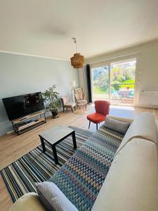 ein Wohnzimmer mit einem Sofa und einem TV in der Unterkunft Appart T4 85m2 spacieux climatisation parking in Rodez