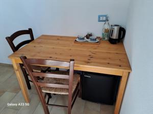 mesa de madera con 2 sillas y cafetera en Sa Cannizzada, en Funtana Meiga