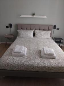 uma cama com duas toalhas brancas em cima em LaCasetta em Burago di Molgora