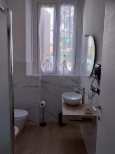 uma casa de banho com um lavatório, um WC e 2 janelas. em LaCasetta em Burago di Molgora