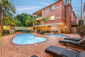 a courtyard with a swimming pool in front of a building at Terralong Terrace Apartments in Kiama