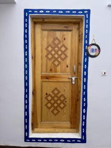 een houten deur in een blauw en wit frame bij Moksha, Losar in Losar
