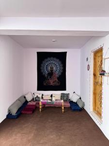 een woonkamer met een bank en een schilderij aan de muur bij Moksha, Losar in Losar