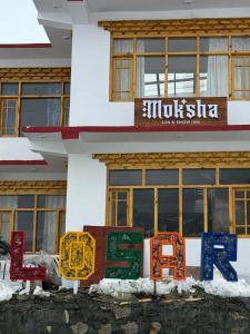 een gebouw met kleurrijke borden ervoor bij Moksha, Losar in Losar