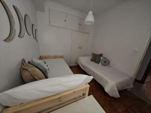 Habitación pequeña con 2 camas y paredes blancas. en a casa da Alicia, en Monforte de Lemos