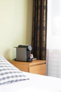 a bedroom with a bed and a dresser with a microwave at Motel-Restaurant 13 Etoiles in Sierre