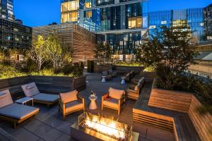 a patio with chairs and a fire pit and a building at Orchard Group Boston in Cambridge