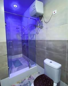 a shower with a glass door in a bathroom at Irish Apartment in Kasoa