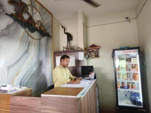 a man sitting at a counter in a restaurant at Hotel GD Stay Inn Near Mahura Chhak in Bhubaneshwar