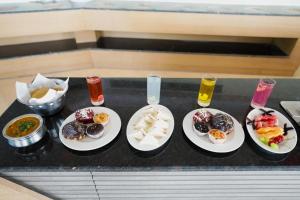 a tray with four plates of food on a table at Hotel Grand regus in Bangalore