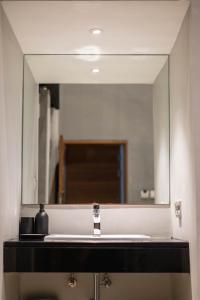 a mirror above a sink in a bathroom at Woodstory Boutique Hotel in Bangkok