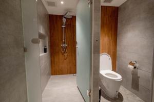 a bathroom with a toilet and a shower at Woodstory Boutique Hotel in Bangkok