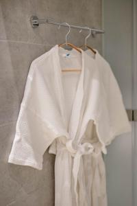 a white shirt hanging on a rack in a bathroom at Woodstory Boutique Hotel in Bangkok