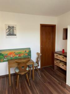 een kamer met een tafel, 2 stoelen en een bureau bij Wohnung Apartments Beny in Bad Bellingen