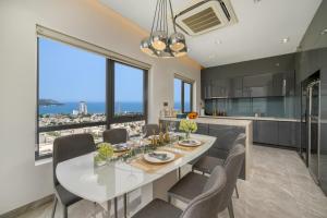 une cuisine et une salle à manger avec une table et des chaises blanches dans l'établissement Penthouse Duplex 4 bedrooms Ocean View, Rooftop Pool, à Đà Nẵng
