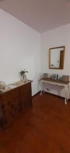 Cette chambre comprend un miroir mural et une commode. dans l'établissement CASA AFFITTO Macchia Saponara, à Acilia