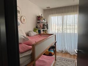een slaapkamer met een bed met roze lakens en een raam bij Designer Penthouse - Outdoor & Light in Castellón de la Plana