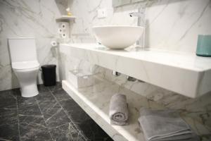 ein weißes Bad mit einem Waschbecken und einem WC in der Unterkunft E&R-2 Plaza España in Salamanca