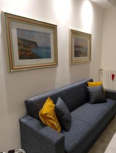 a living room with a blue couch with yellow pillows at Interno27 in Naples