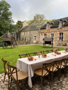 a table in front of a stone house with a table and chairs at ABBAYE DE BLANCHELANDE in Neufmesnil