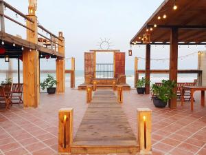 un pabellón con mesa y bancos en la playa en Chavi Beach - Coffee and Homestay en Bình Tú