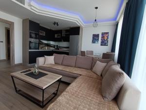uma sala de estar com um sofá e uma mesa em 18th Floor Secure Luxury Condo With Pool & Fitness Included In Price em Skopje