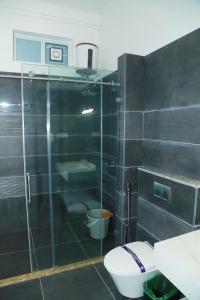 a bathroom with a toilet and a glass shower at Kolaahalam Mainland Resorts & Spa in Yercaud