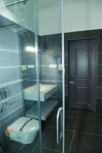 a bathroom with a toilet and a glass door at Kolaahalam Mainland Resorts & Spa in Yercaud