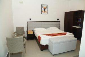 a bedroom with a large bed and a chair at Kolaahalam Mainland Resorts & Spa in Yercaud