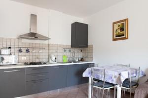 a kitchen with blue cabinets and a table with chairs at Casa Maya in Sarnano