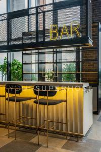 a bar with two stools in front of a building at Millerz Square Tower E Near MidValley by YourSuperhost in Kuala Lumpur