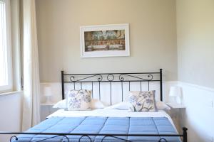 1 dormitorio con cama negra con sábanas y almohadas azules en Cilento Suite - Louis XXII, en Agropoli