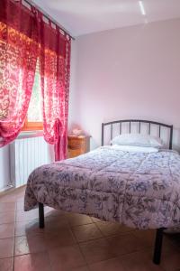a bedroom with a bed with pink curtains and a window at Casa Maya in Sarnano