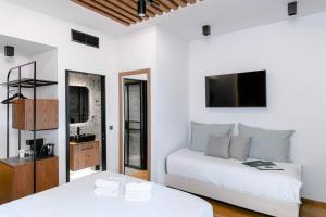 a white bedroom with two beds and a tv at Snob Athens in Athens +53 photos