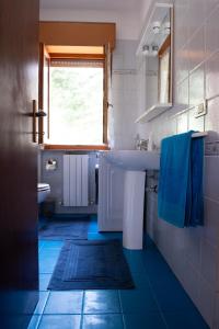 baño con lavabo y ventana en Casa Maya, en Sarnano
