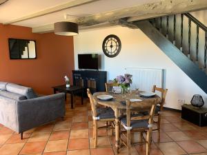 ein Wohnzimmer mit einem Tisch und einem Sofa in der Unterkunft COTTAGES LA CHENERIE in Ancteville