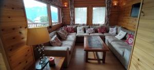 a living room with a couch in a log cabin at CHALET MARAMU in Puy-Saint-Pierre