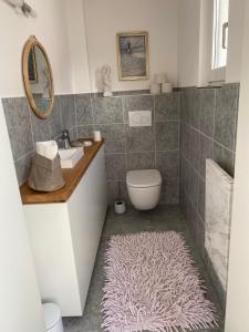 a bathroom with a sink and a toilet and a rug at Gästehaus LuNa in Zeil