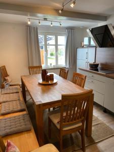 a kitchen and dining room with a wooden table and chairs at Gästehaus LuNa in Zeil