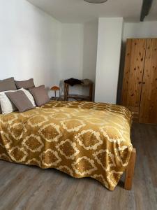 a bedroom with a bed with a yellow blanket at Gästehaus LuNa in Zeil